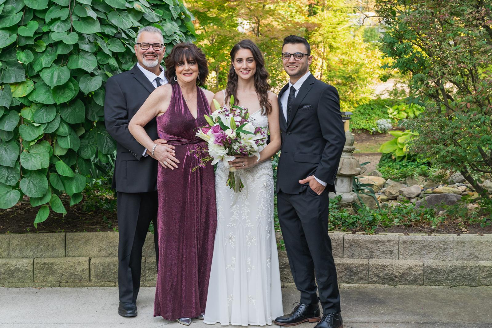 Bride with family, family portrait, classy, formal, beautiful bouquet of flowers, plants, nature, trees, stone, green, classy wedding ceremony at Landerhaven, Mayfield Heights OH