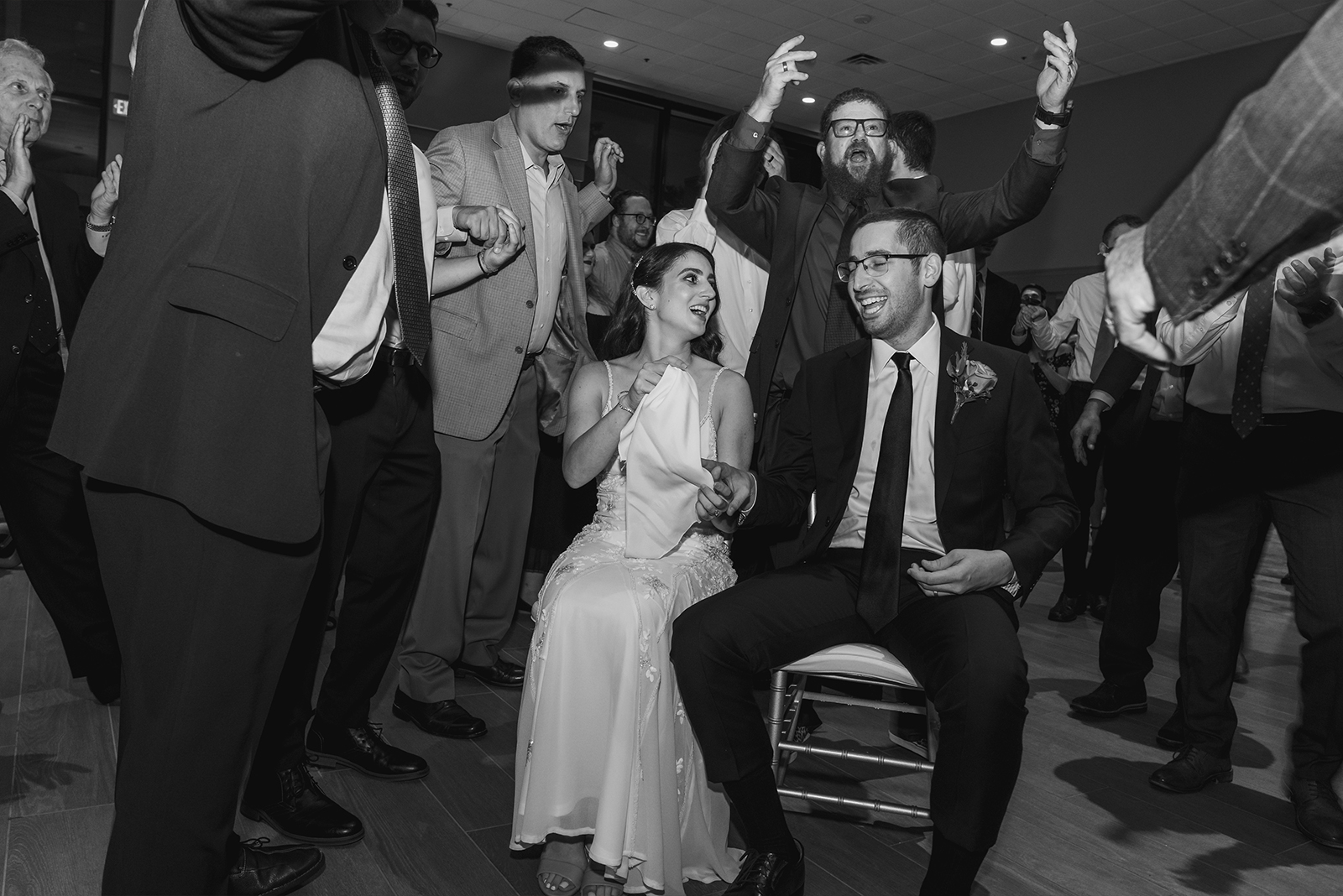 Bride and groom in chairs, dance, fun, black and white, candid wedding photo, Jewish wedding, classy wedding ceremony at Landerhaven, Mayfield Heights OH