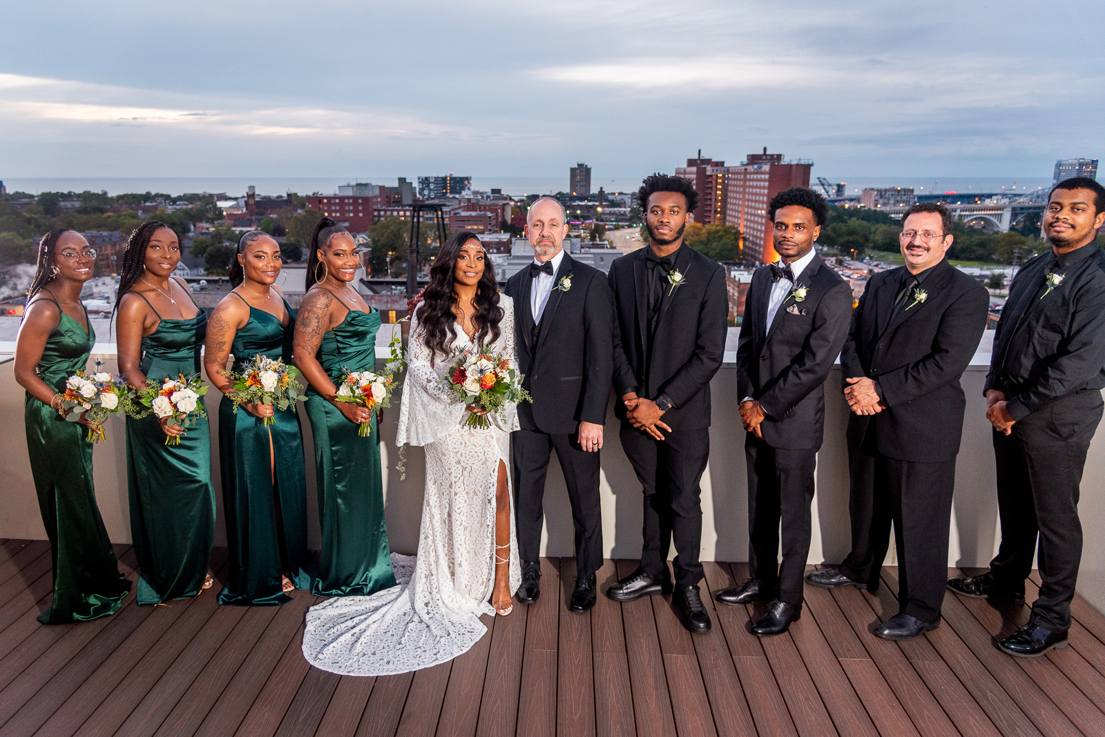 Bride and groom with bridal party, bridal party portrait, African American bride, African American wedding, sunset wedding photo, downtown Cleveland skyline, Lake Erie, urban wedding ceremony at Penthouse Events, Ohio City, Cleveland Flats