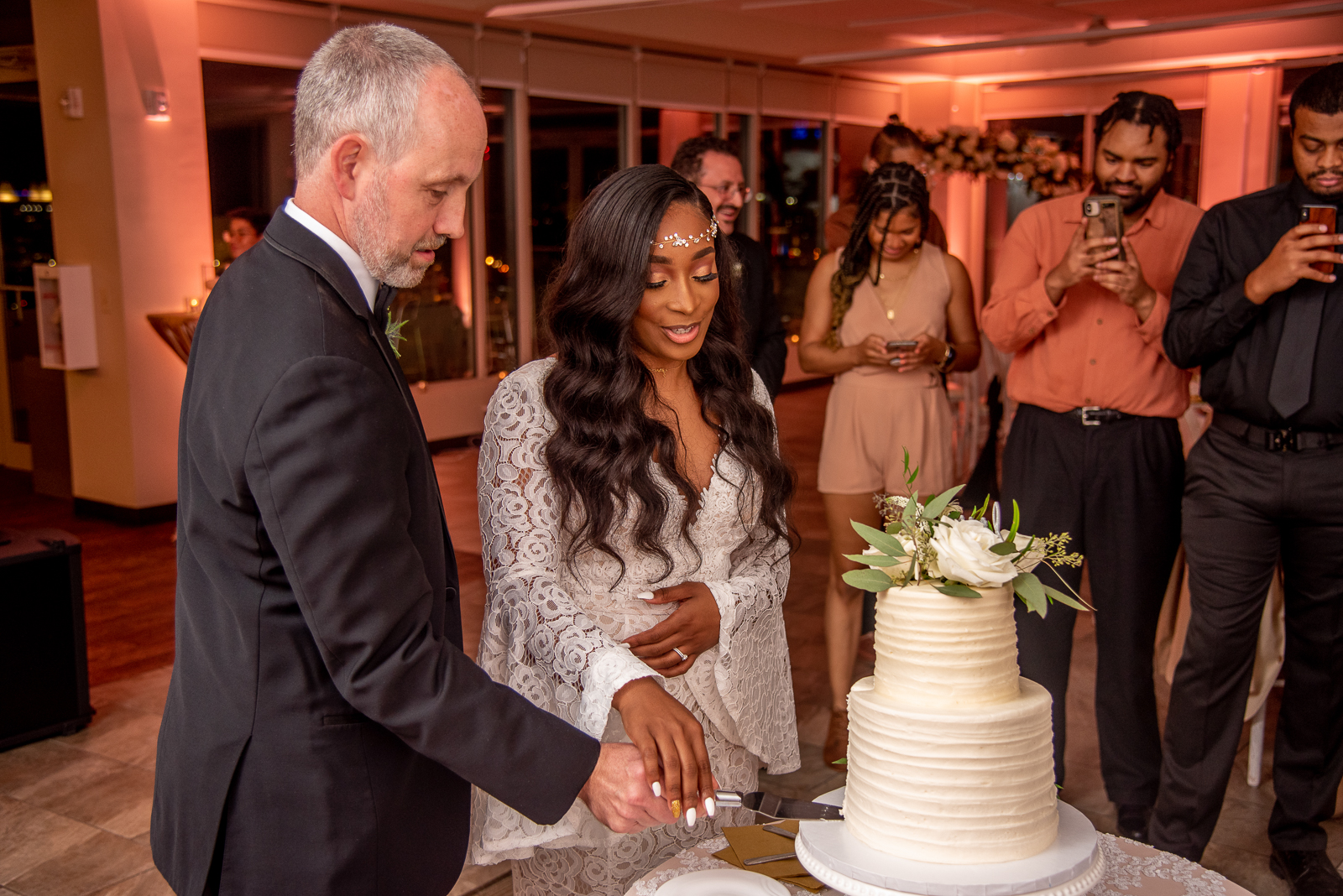 Bride and groom cutting the cake, African American bride, pink light, pink uplighting, romantic, African American wedding, urban wedding reception at Penthouse Events, Ohio City, Cleveland Flats
