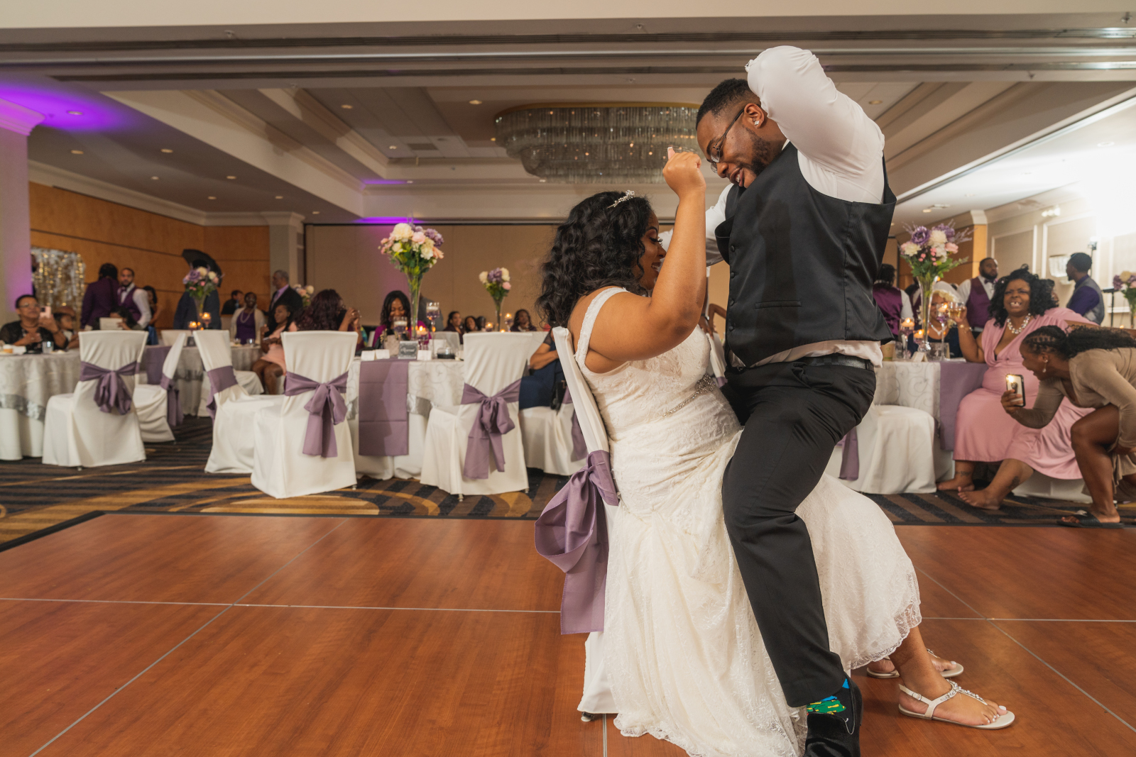 Groom dances on bride, garter removal, fun wedding photo, bride cheering, funny, African American bride, African American wedding, romantic wedding reception at Hilton Akron/Fairlawn