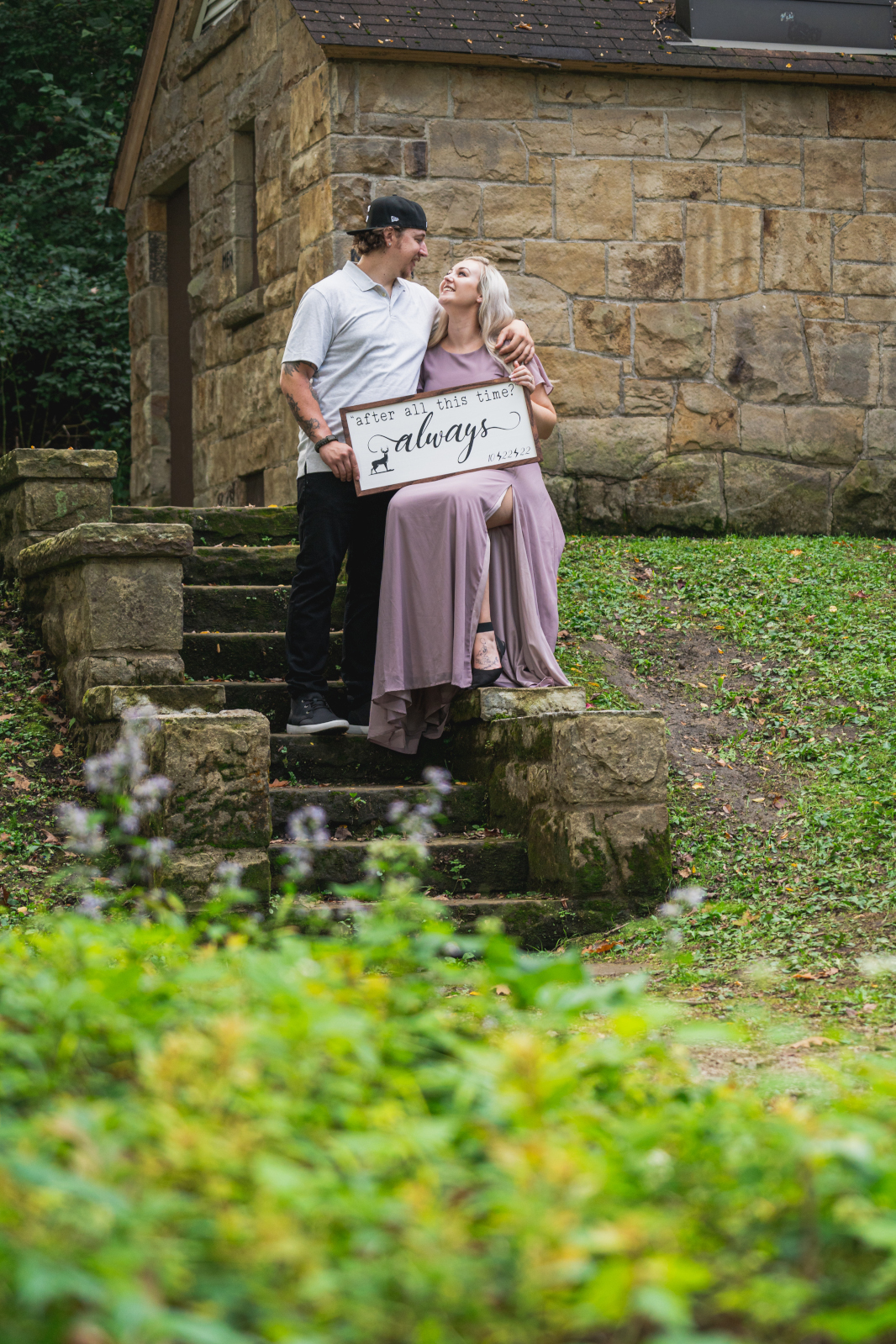 Man and woman fiancee engagement photo, couple portrait, Harry Potter sign photo prop, always, love, stone steps, trees, nature, outdoor fall engagement photo session at Grand Pacific Junction Historic Shopping District