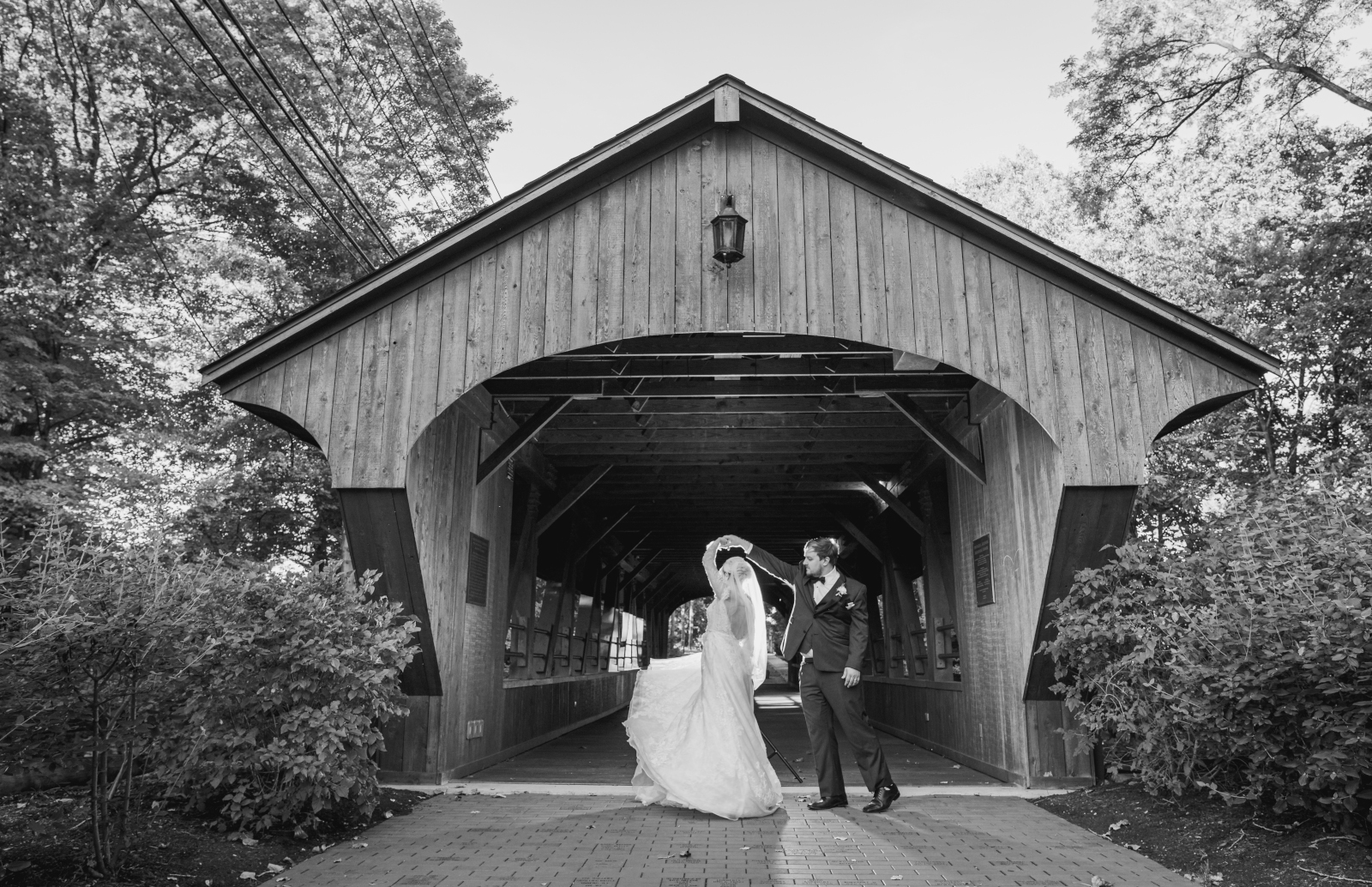 Bride and groom wedding portrait, dance, spin, backlight, wedding dress, classic, unique wedding photo, black and white, covered bridge, nature, trees, fall wedding, cute outdoor wedding ceremony at Grand Pacific Wedding Gardens