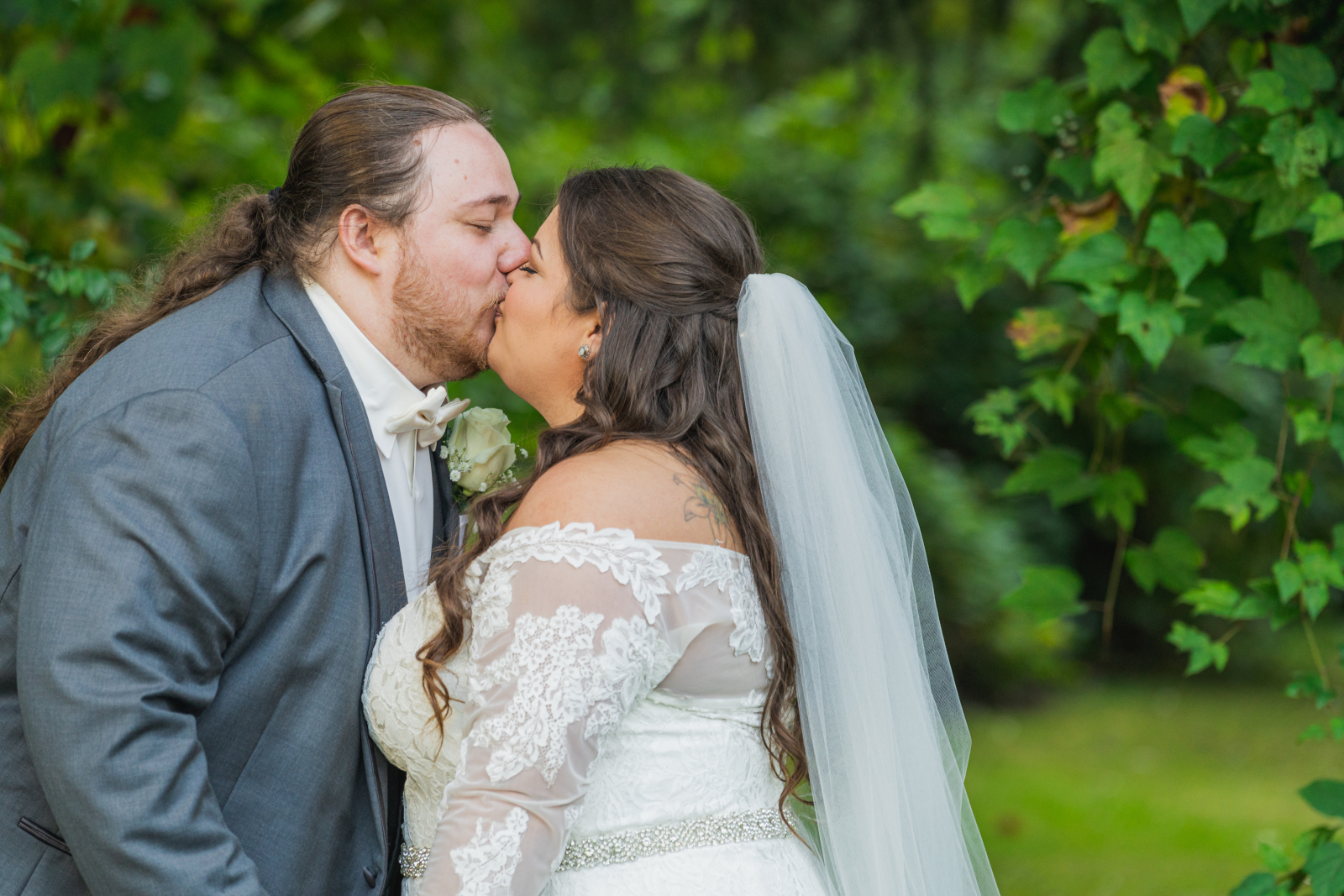 Bride and groom wedding portrait, kiss, green, nature, trees, outdoor September wedding ceremony at Westfall Event Center