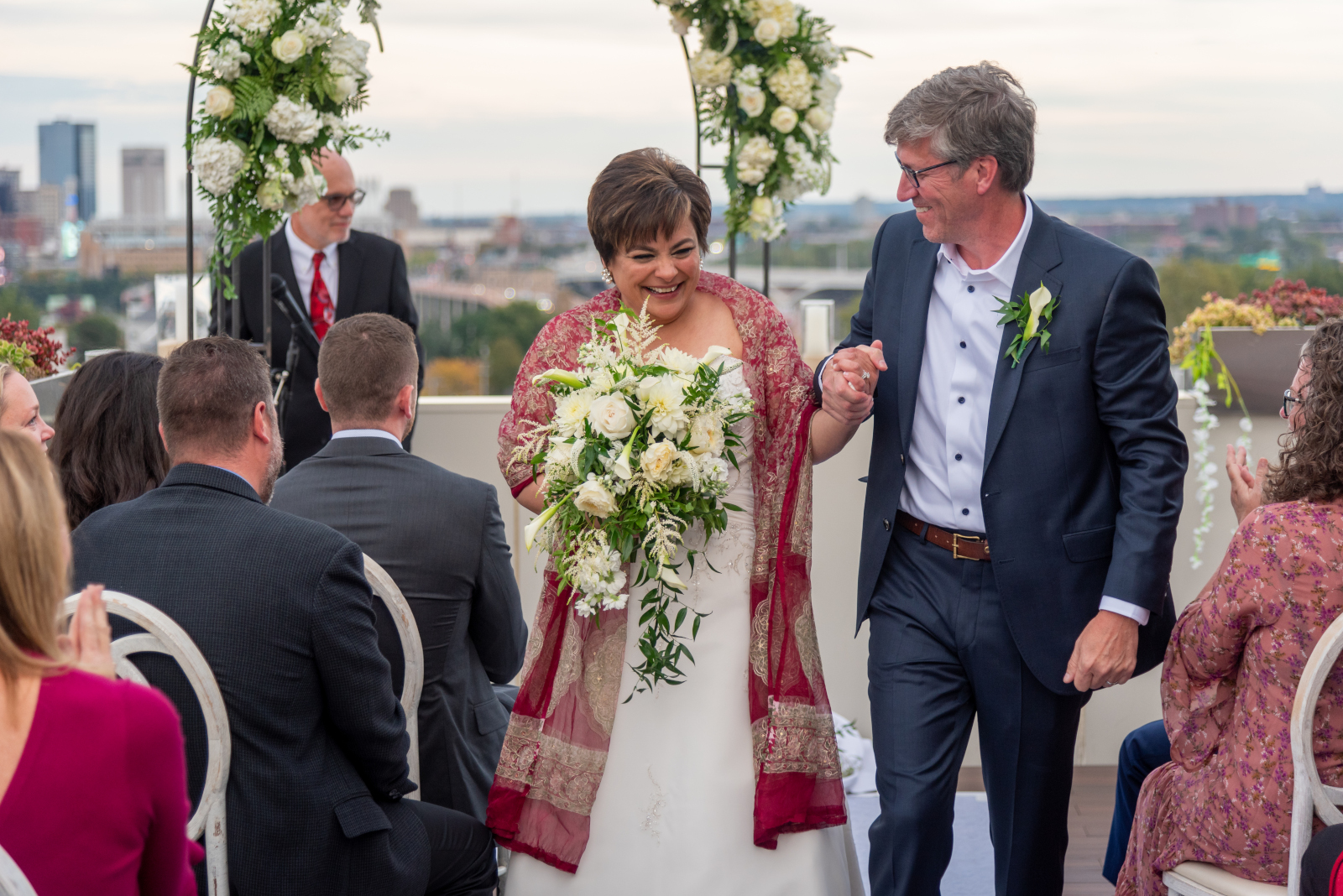 Bride and groom walking down the aisle, bridal recessional, wedding ceremony, smiling, laughing, sweet, cute, older couple, romantic outdoor urban wedding ceremony at Penthouse Events, Ohio City, Cleveland Flats, downtown Cleveland skyline