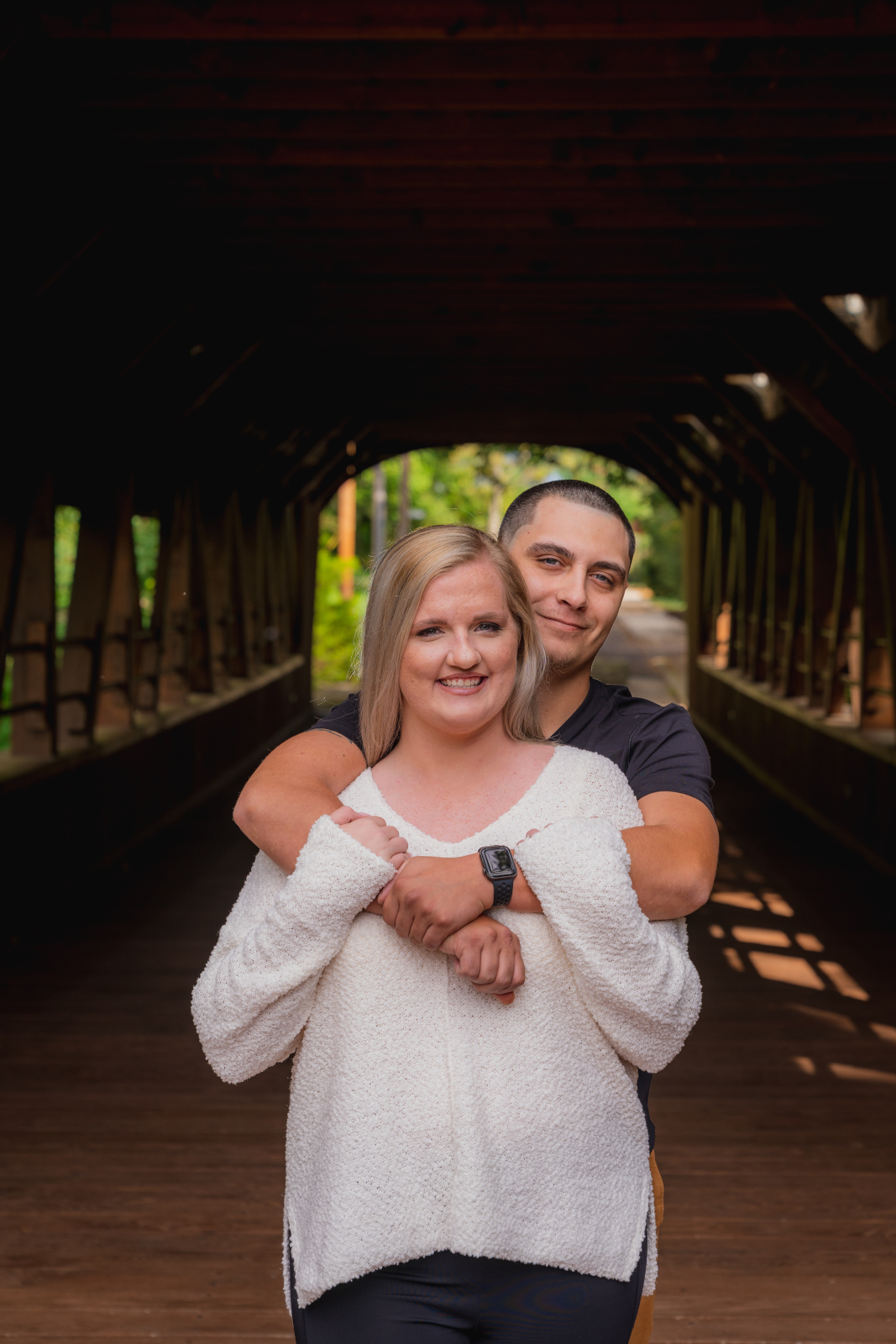 Man and woman fiancee engagement photo, couple portrait, smile, covered bridge, nature, outdoor fall engagement photo session at Grand Pacific Junction Historic Shopping District
