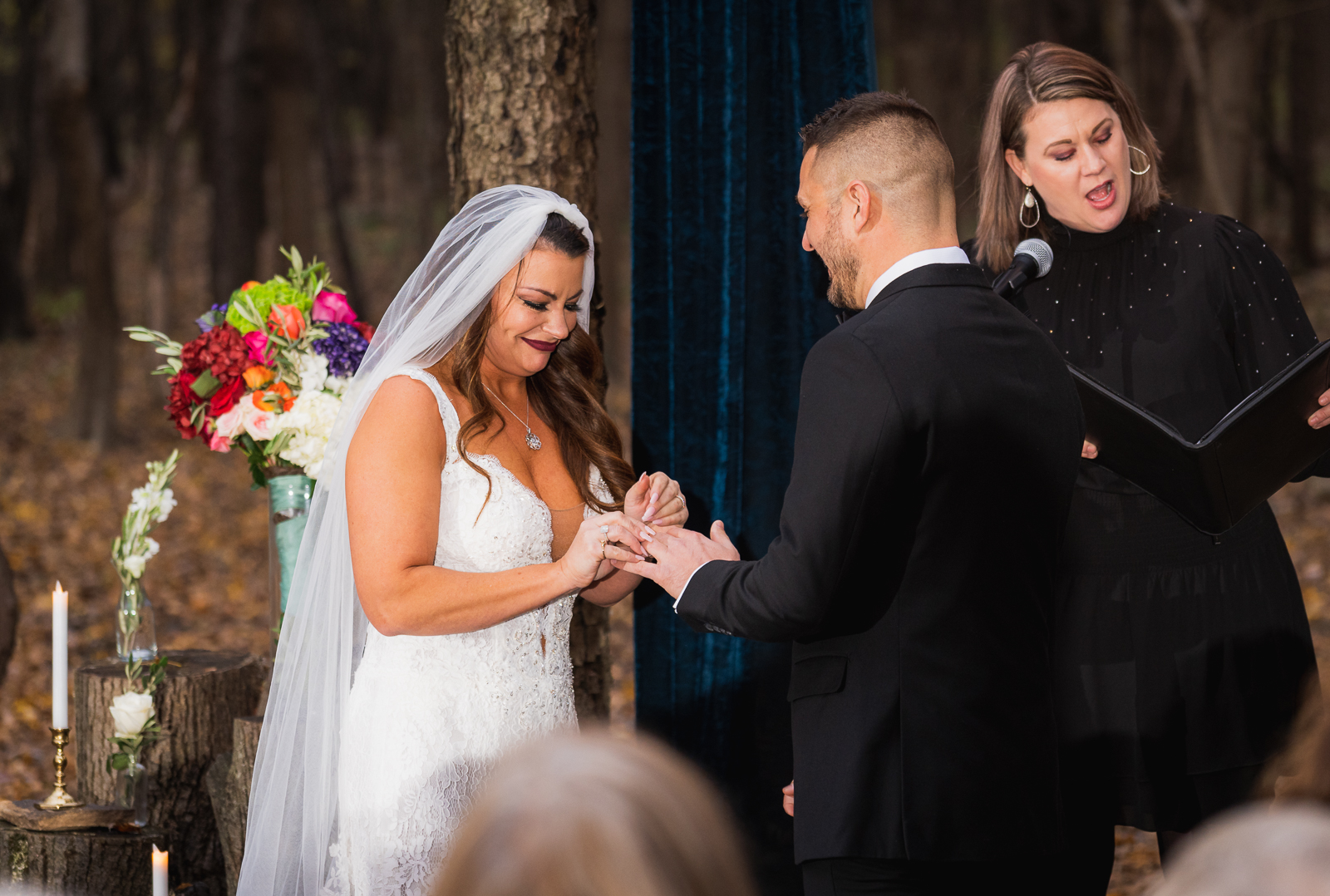 Bride and groom exchange rings, outdoor wedding ceremony at Gather at the Lakes