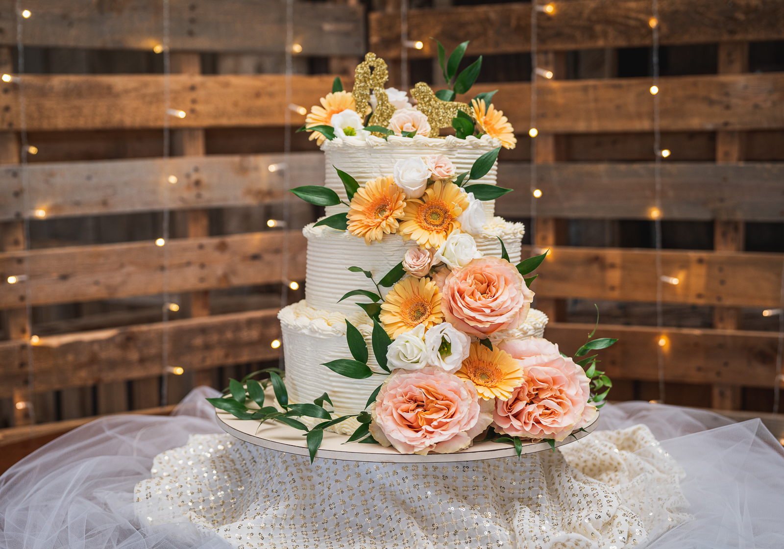 Wedding cake, flowers, cute wedding cake topper, cute cake topper, gold, glitter, string lights, wood panels, pallets, fall wedding, rustic wedding reception at White Birch Barn