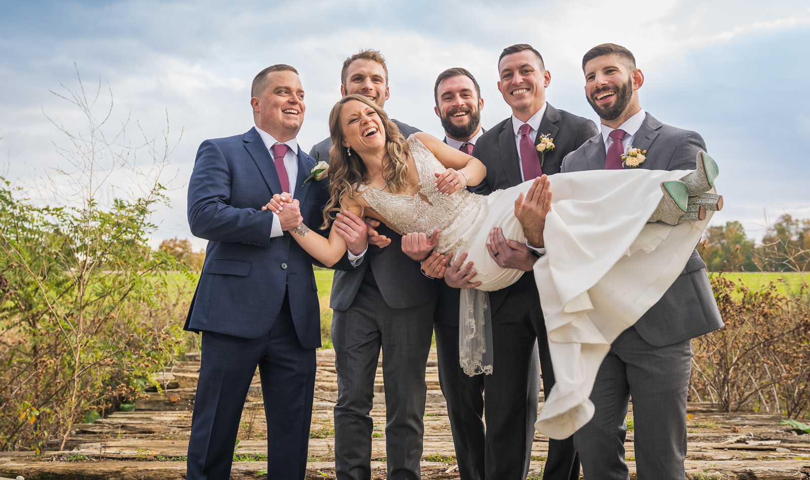 Bride with groomsmen, bridal party portrait, fun bridal party portrait, candid, laugh, fall wedding, rustic outdoor wedding ceremony at White Birch Barn