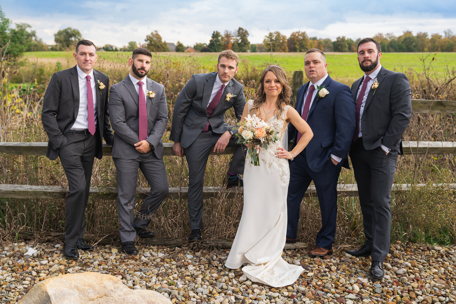 Bride with groomsmen, bridal party portrait, field, nature, fence, fall wedding, rustic outdoor wedding ceremony at White Birch Barn