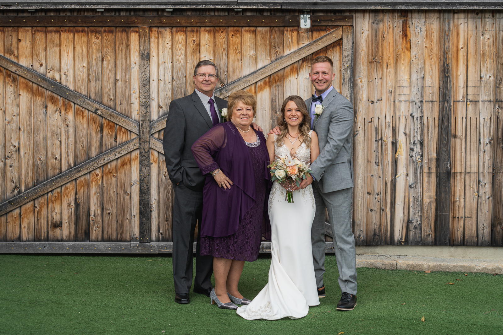 Bride and groom with bride's parents, mom and dad, family portrait, wedding photo, fall wedding, rustic outdoor wedding ceremony at White Birch Barn